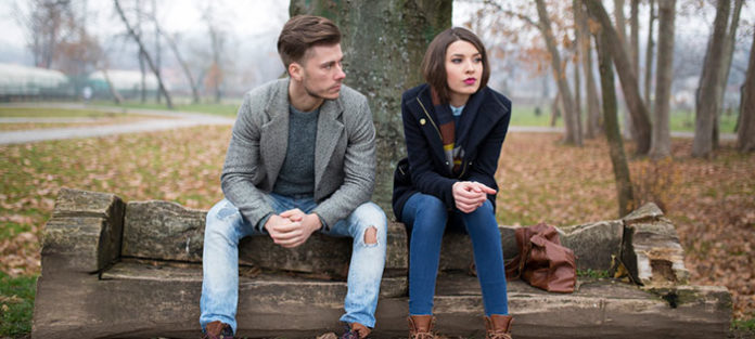 Unhappy couple sitting outside