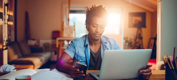 male on his computer and cell phone