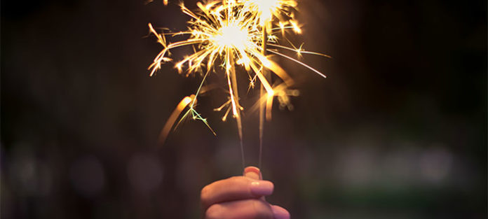 Person-holding-up-a-sparkler Person-holding-up-a-sparkler