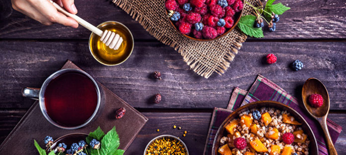 Assortment of tea, honey, and fruit on a table