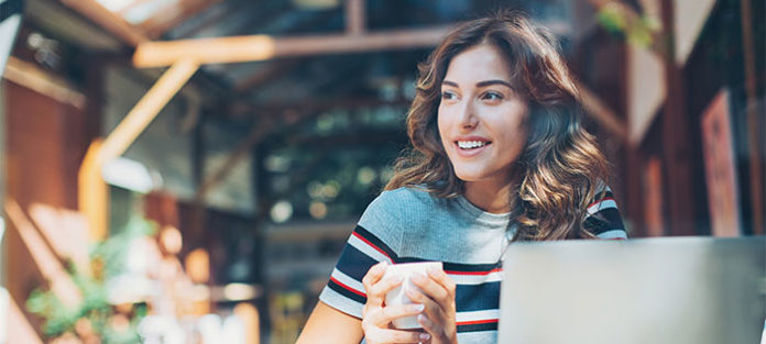 Young woman sitting in a coffee shop on her laptop
