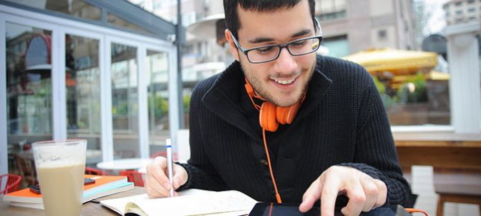 Guy taking notes and using an iPad