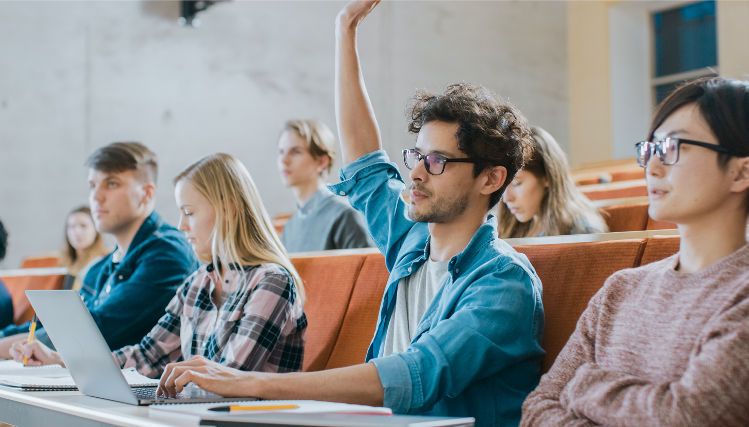 Hispanic student raising hand in class | tips for studying in graduate school