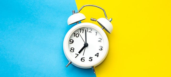 alarm clock on blue and yellow background