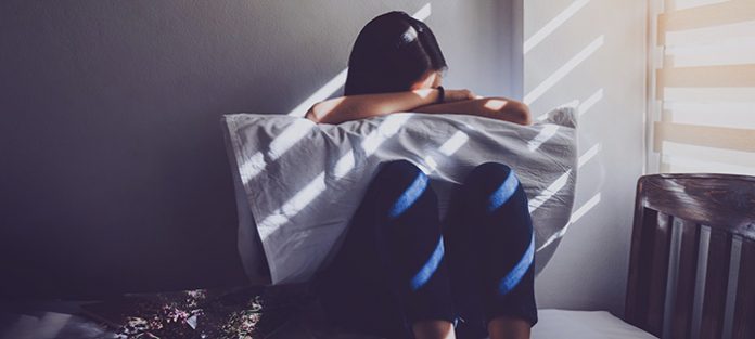 1119_CONWomen_AskProf_Feat Woman sitting in bed behind pillow