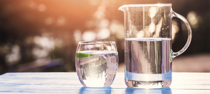 drinking glass and pitcher of water on picnic table drinking glass and pitcher of water on picnic table
