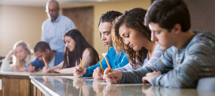 Group of students taking exam in class
