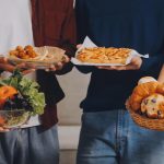 How to eat intuitively and improve your relationship with food Group of people holding various foods including vegetables, pastries, and fried snacks.