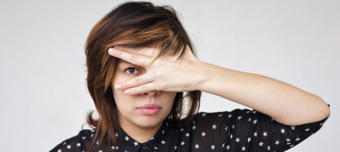 Girl peeking through her hand