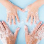5 easy steps to keep your hands germ-free Adult and child washing hands together with soap bubbles on a blue background.