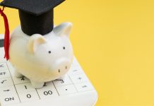piggy bank standing on top of calculator, yellow background | how to save money for graduate school
