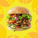 Colorful stacked veggie burger on a bold yellow background with playful graphic accents.