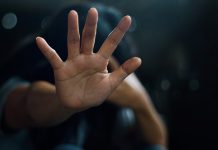 Ask the counselor: “How do you deal with negative feelings from a traumatic event in your past?” Person raising hand defensively, symbolizing trauma, boundaries, or emotional protection.