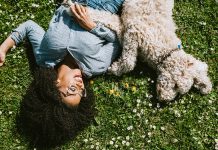 Girl with dog laying in grass