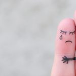 Two fingers hugging, one sad and one comforting, representing emotional support and dependency