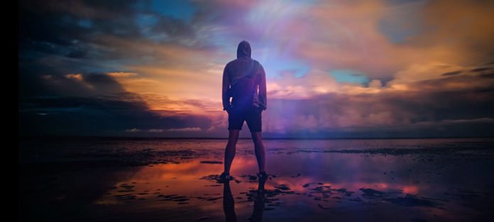 confident male looking into stormy sunset