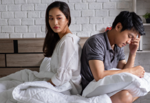 Ask the sexual health expert: “Is there something wrong with me that I really don’t ever have an orgasm?” couple sitting in bed together, upset | why don't I orgasm