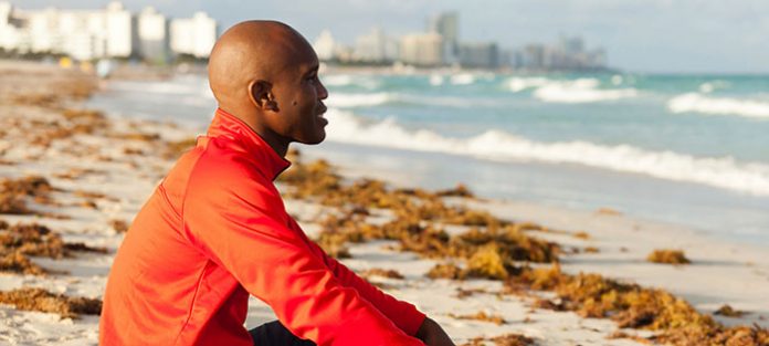 guy sitting on beach looking out
