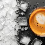 Hot coffee cup next to melting ice cubes on a dramatic black-and-white split background.