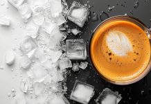 Hot coffee cup next to melting ice cubes on a dramatic black-and-white split background.