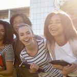 20 things college students learned the hard way - so you don't have to Group of diverse, happy students standing outdoors, holding books and notebooks on campus.