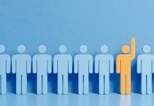 A row of blue human icons with one yellow figure raising its hand, symbolizing uniqueness.