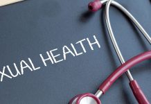 Blackboard with "Sexual Health" written in chalk and a red stethoscope draped across it.