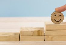 Wooden blocks stacked like steps, with a round block featuring a smiling face on top.