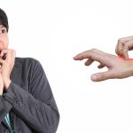 Ask the doc: Person recoiling as another hand points to a red, irritated patch on their skin.