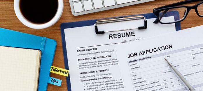 resume, job application, and notebook on desk