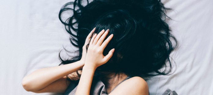 Anxious girl tossing in bed