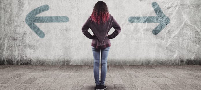 rearview of female looking at arrows points in opposite directions