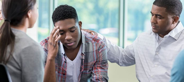 Sad guy being consoled in therapy