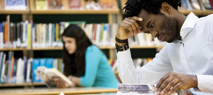 Guy reading in library