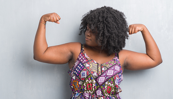 confident Black female flexing biceps | why should college students exercise